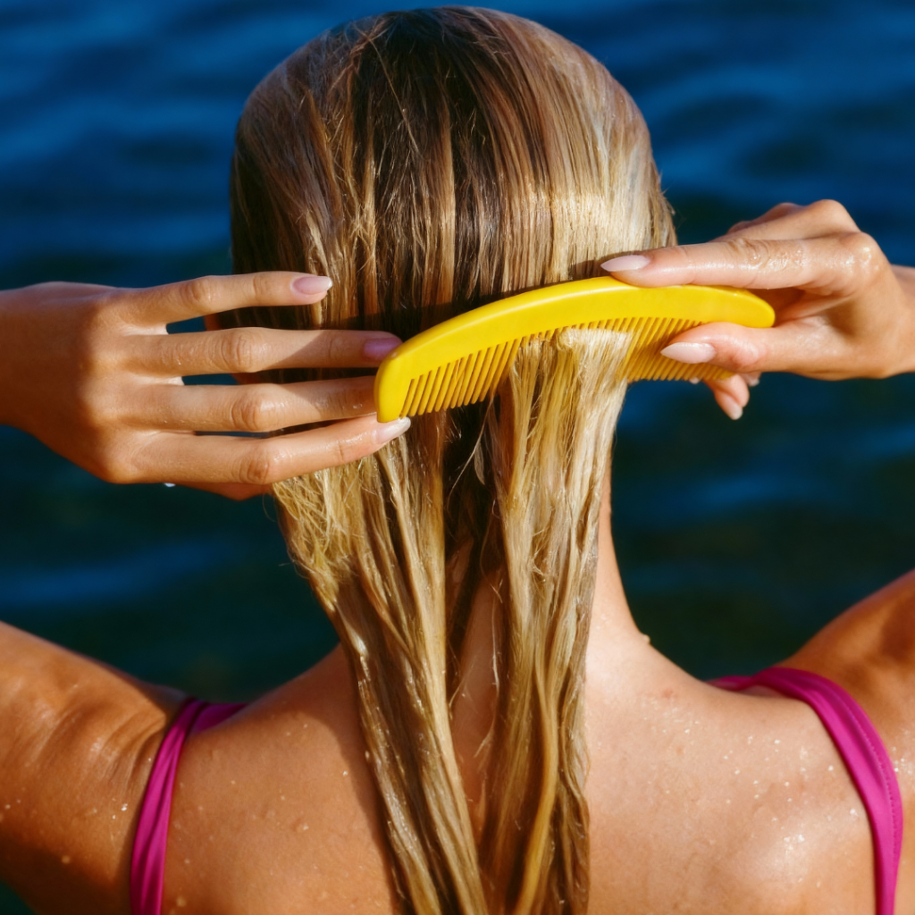 Woman brushing wet hair by the water, refreshing scalp and hair in warm weather
